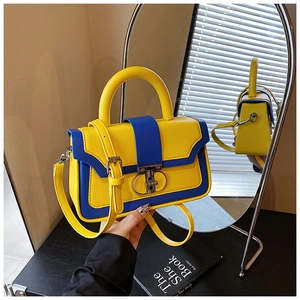 Detail view of yellow and blue contrast handbag with metallic ring lock and smooth leather