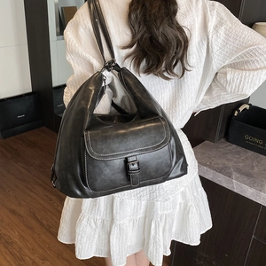 Minimalist large capacity backpack in dark grey leather shown on model for casual wear