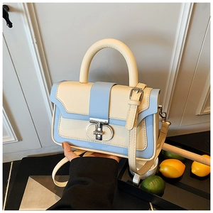 Detail of a vintage square handbag with contrast colors and round metal clasp detail