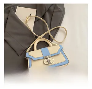 Detail of a color-block handbag featuring a silver twist lock and minimalist flap closure