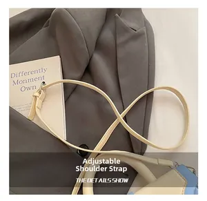 Detail of adjustable beige leather shoulder strap with metallic buckle on a stylish box bag