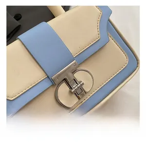 Close-up of the large silver circular metal buckle on the light blue leather handbag