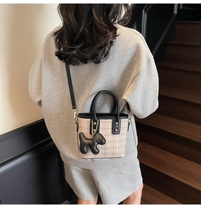 Beige plaid mini tote bag with black leather handles and cute puppy charm on model