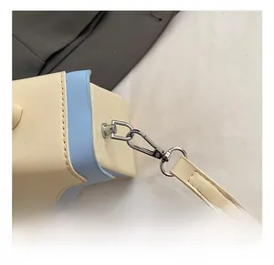 Detail shot of silver rotating metal hooks and stitching on two-tone leather bag
