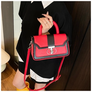 Detail of red and black leather handbag featuring a silver interlocking circular twist lock