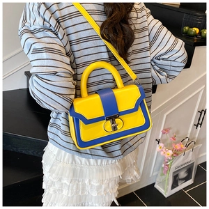 Detail of yellow and blue contrast handbag with metal ring clasp and round handle
