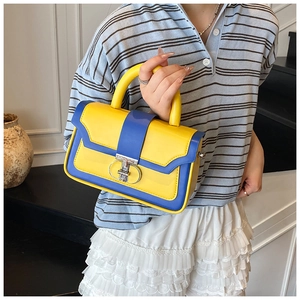Detail of yellow and blue square handbag with silver ring buckle and top handle strap