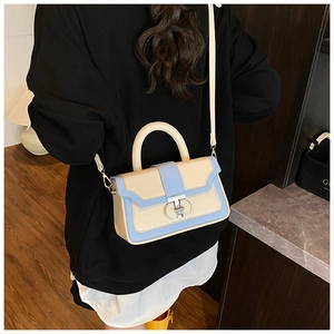 Detail of two-tone cream and blue PU leather handbag with silver metal ring lock detail