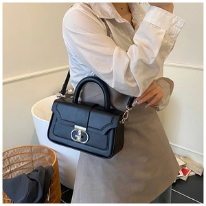 Detail of black leather crossbody bag with silver Gancini style buckle and slim strap