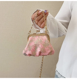 Detail view of pink and gold tweed weave texture and vintage metal clasp closure