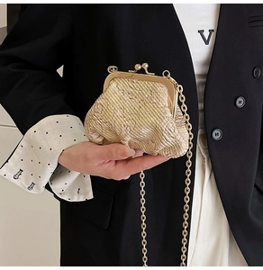 Detail of elegant gold woven evening bag with metallic clasp and chain strap