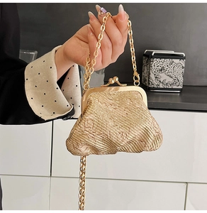 Detail of champagne gold woven evening bag with metallic finish and gold clasp