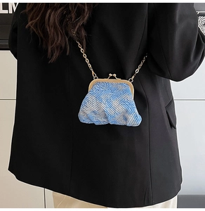 Detail of blue tweed mini crossbody bag with gold vintage clasp and chain strap