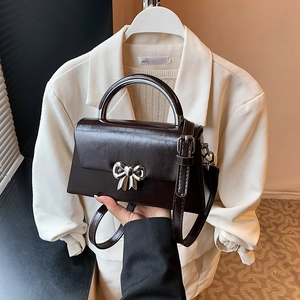 Chic dark chocolate PU leather crossbody bag with silver bow clasp and adjustable strap
