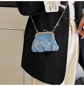 Detail of mini tweed crossbody bag with blue contrast weave and gold metal clasp