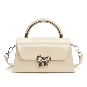 Minimalist cream shoulder bag with silver bow accent and metallic handle design