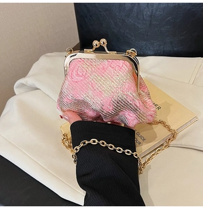 Detail of pink and gold woven jacquard mini clutch bag with metal kiss lock and chain