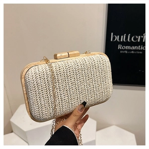 Detail shot of woven straw clutch with wooden frame and detachable gold chain strap