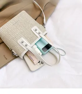 Interior view of straw tote bag showing capacity for phone, power bank and cosmetics