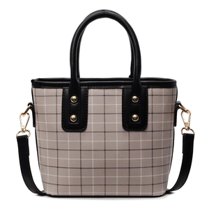 Classic checkered tote bag with black leather trim and golden studs on white background