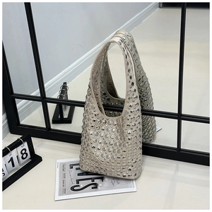 Detail of apricot hobo bag with silver metallic rivets and sleek side profile reflection