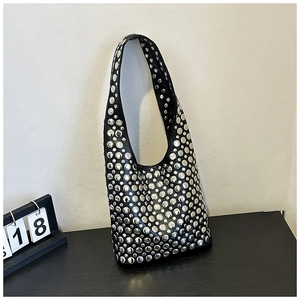 Close-up of black punk shoulder bag featuring multi-sized silver metal rivet decorations