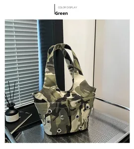 Detail of green camouflage canvas bag with multi-pocket design and silver grommets