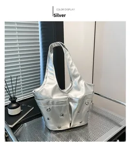 Detail view of a silver tote bag with metallic grommets on a modern industrial grid table