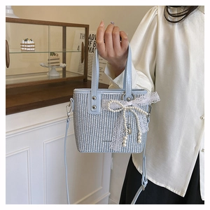 Detail of blue and white woven bag with pearl lace bow and fashion lettering