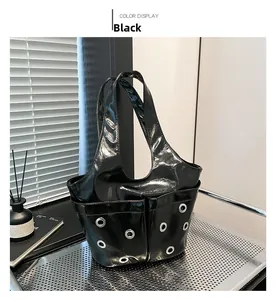 Detail of glossy black patent leather bag with metallic eyelets on the side