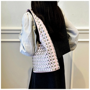 Detailed view of pink leather underarm bag featuring scattered silver metal rivet studs