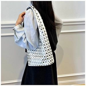 Detail of white crescent shoulder bag with metallic rivets and trendy silver stud accents