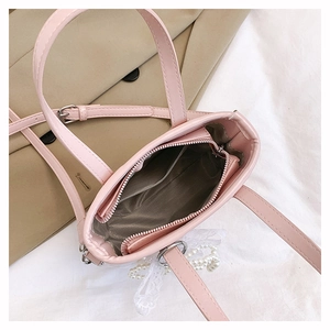 Top view of pink mini handbag showing interior compartment with lace bow and pearl charm