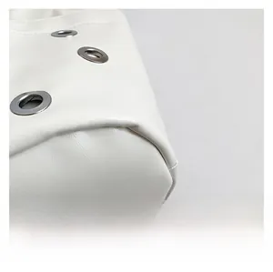 Detail view of white faux leather underarm bag with decorative silver metal eyelets
