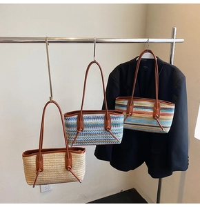 Detailed view of woven straw tote bags with leather handles and bohemian wave patterns