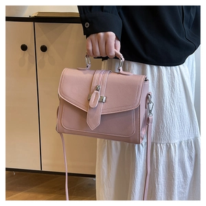 Close-up of pink lychee textured handbag featuring silver buckles and crossbody strap