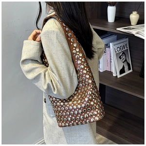 Detail showing vintage brown leather shoulder bag with silver studs on a female model