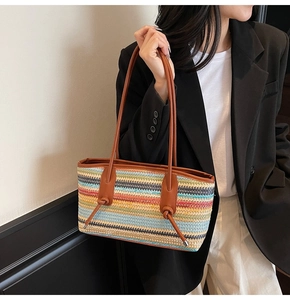 Detail of colorful woven tote bag with brown leather straps and decorative knot crafts