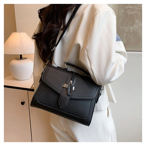 Detail of black lychee grain handbag with silver hardware and adjustable shoulder strap