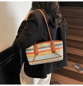 Detail of colorful striped woven tote bag with brown leather straps on shoulder