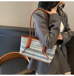 Detailed view of women's woven tote bag with zig-zag pattern and leather handles