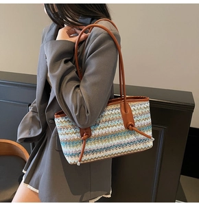 Detail view of woven shoulder bag with vintage wavy pattern and brown leather straps