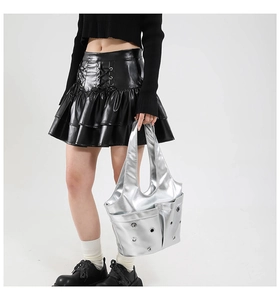 Detail of silver metallic tote bag with multiple pockets and eyelet hardware accents