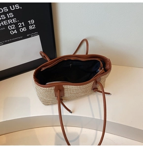 Detailed view of the woven tote bag showing its spacious black lining and interior zipper pocket