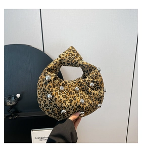 Detail of leopard print handbag with silver rivet studs and knotted handle design