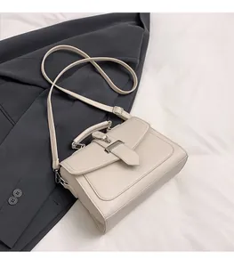 Detail of off-white lychee texture leather shoulder bag with silver metal clasp closure
