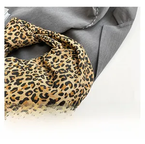 Detail of leopard print fabric handbag with knotted handle and pleated texture design