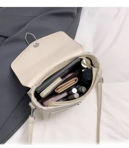 Interior view of off-white crossbody bag showing large capacity and multiple pockets