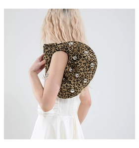 Detail of leopard print crescent shoulder bag featuring silver rivets and pleated texture