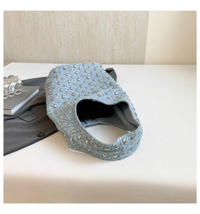 Detail of light blue denim bucket bag featuring silver rivets and sparkling texture
